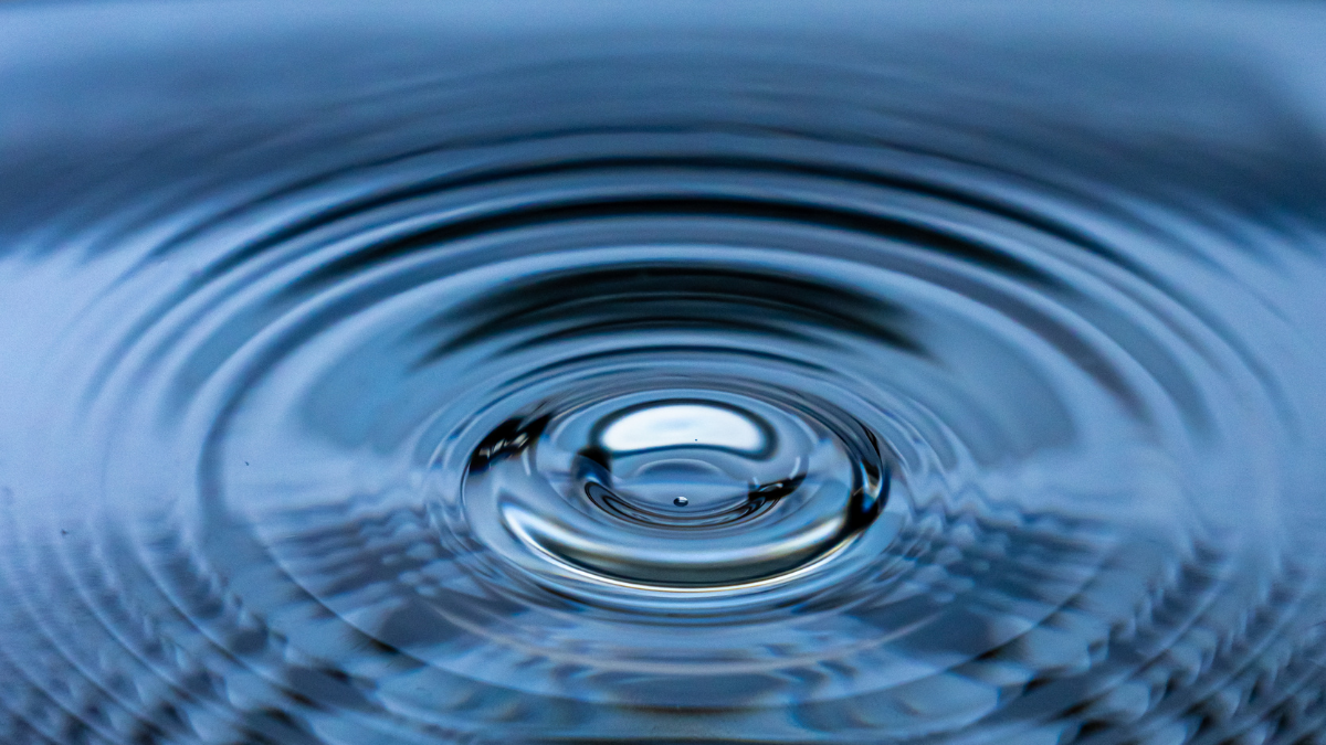 Close-up of concentric water ripples with a drop in the center